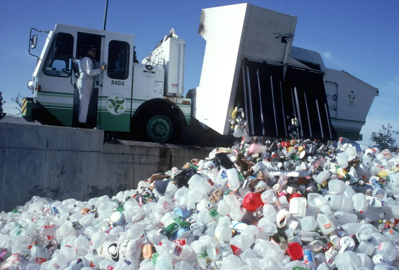 mężczyzna opróżnia ciężarówkę z odpadów plastikowych